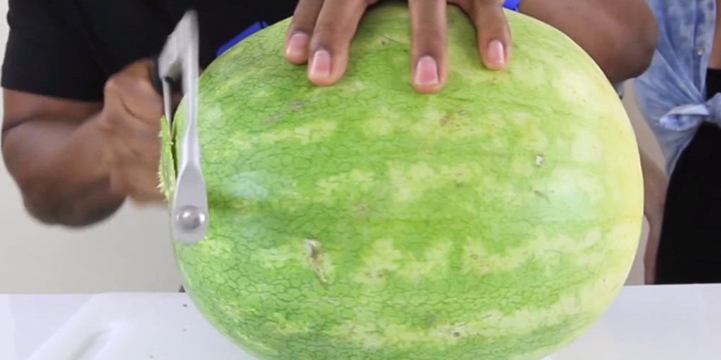 Eine helle Wassermelone wird angeschnitten.