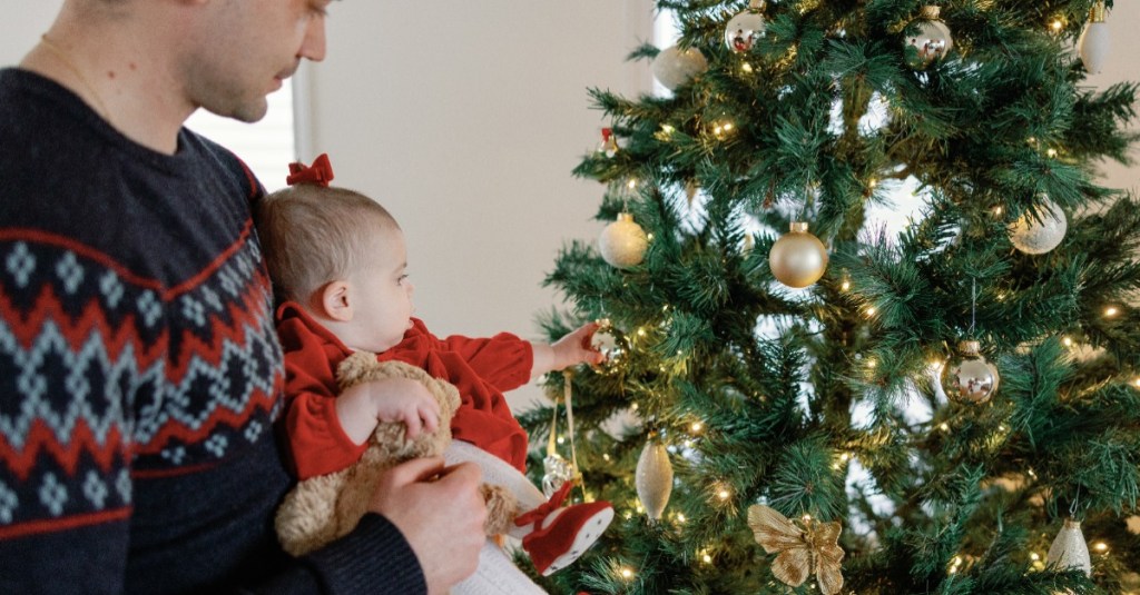 Vater und Babytochter schmücken Weihnachtsbaum