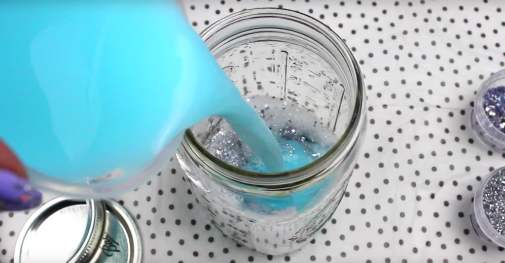 Blaue Farbe wird in ein Glas gegossen.