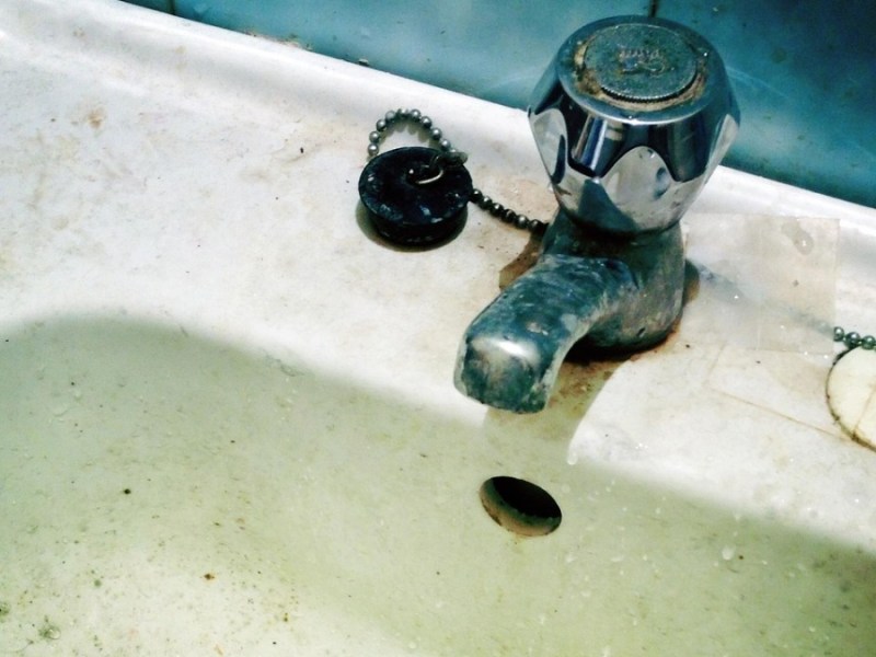 Armaturen reinigen: ein schmutziges Waschbecken mit einem dreckigen Wasserhahn