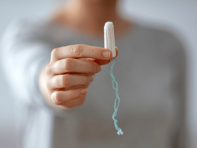 Eine Frau hält einen Tampon in die Kamera.