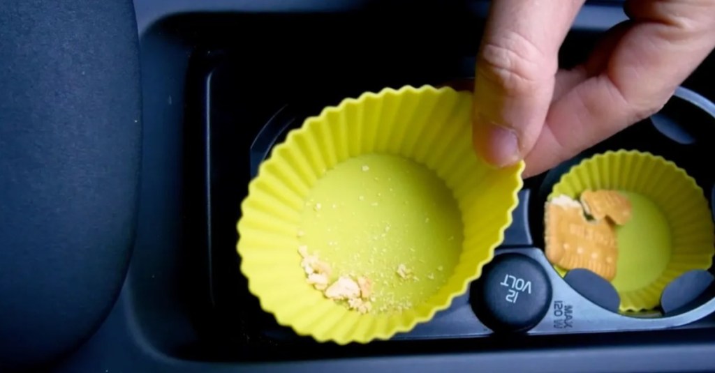 Muffinförmchen werden in die Mulden des Getränkehalters gelegt, um Ordnung im Auto zu halten