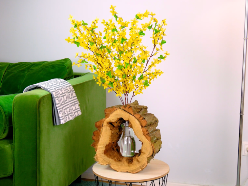 Eine Vase steht in einem ausgehöhlten Baumstamm