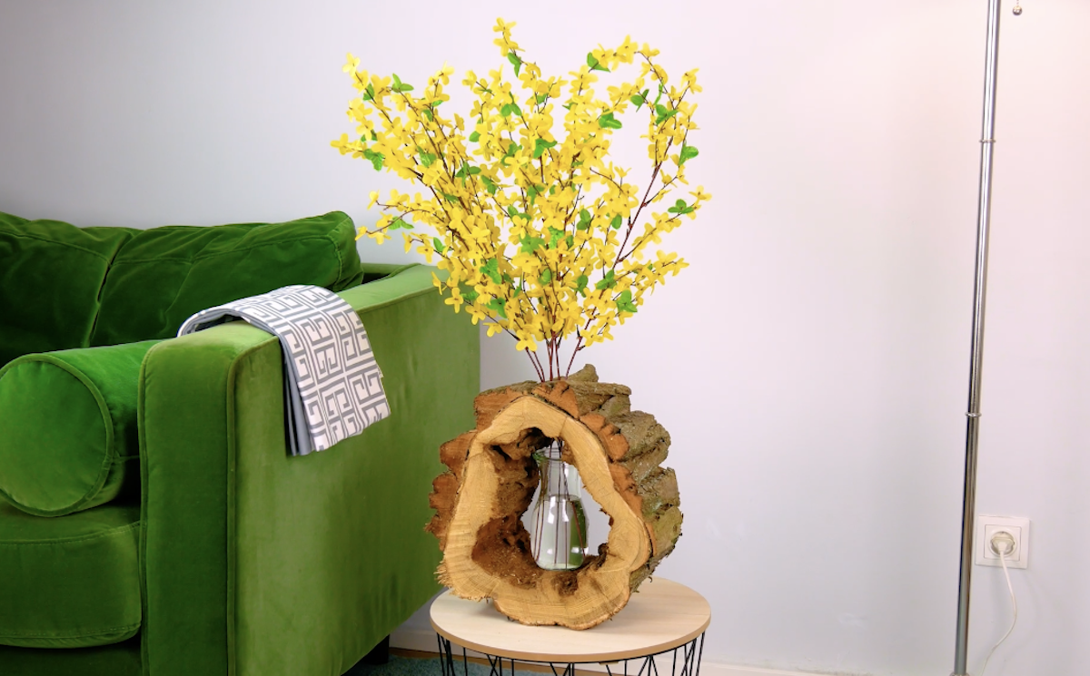 Eine Vase steht in einem ausgehöhlten Baumstamm