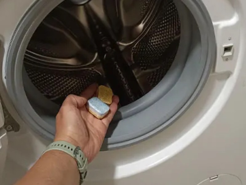Spülmaschinentab in die Waschmaschine legen.