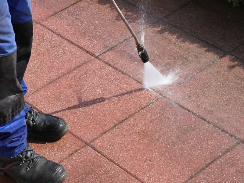 eine Terrasse wird mit einem Hochdruckreiniger gereinigt