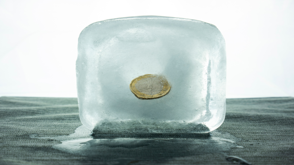 Ein-Euro-Münze gefroren in Eiswürfel.