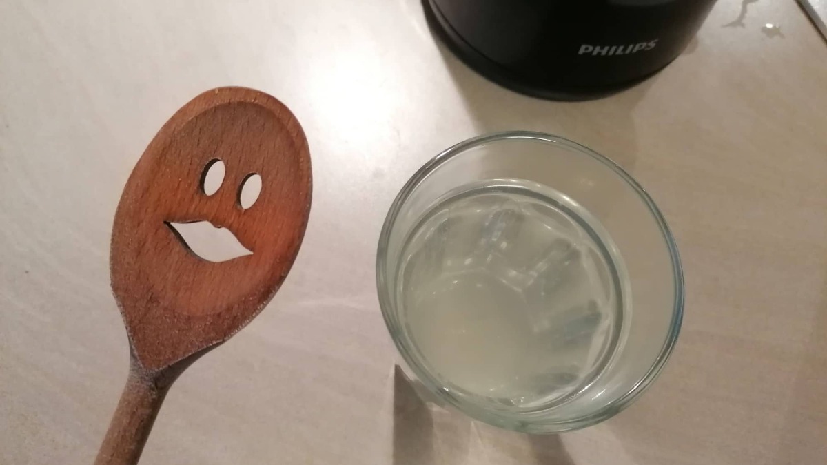 ein Holzkochlöffel neben einem Glas mit Wasser