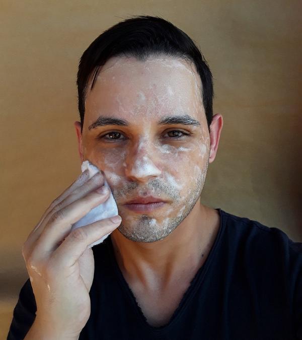 Ein Mann wäscht sich sein Gesicht mit Seife.