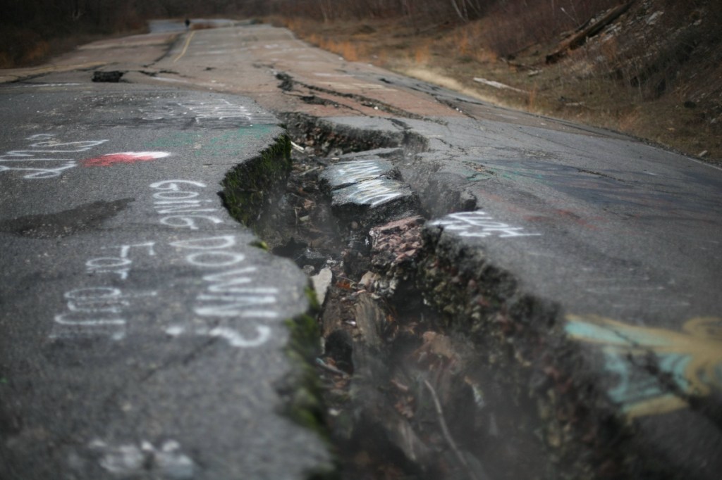 Aufgerissener Asphalt einer Straße.