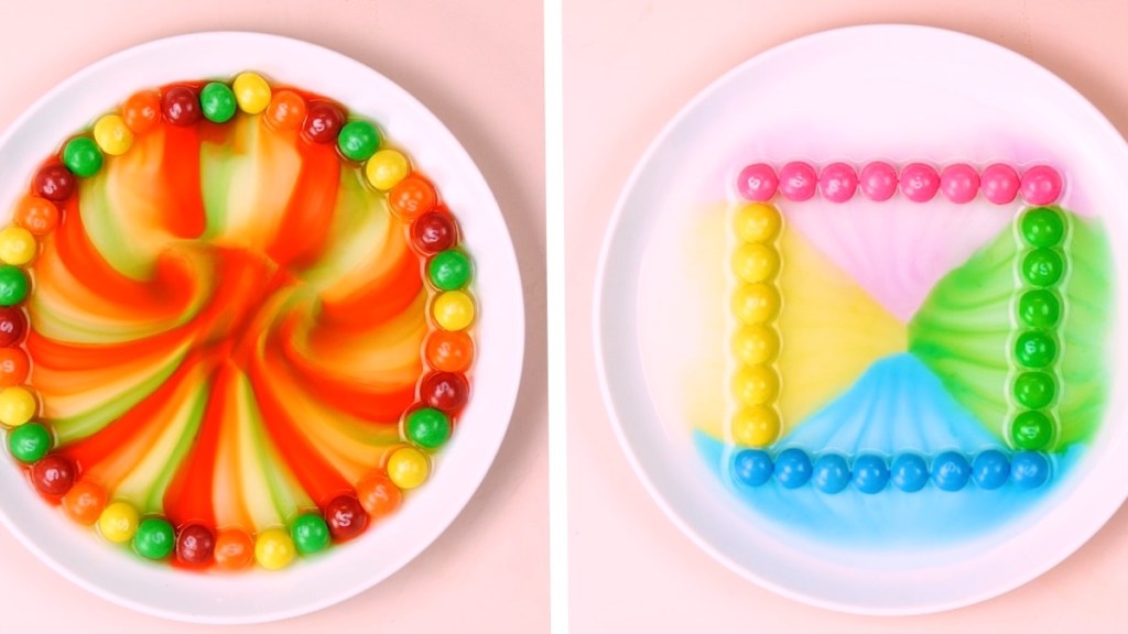 Skittles (Süßigkeiten) lassen mit Zugabe von Wasser bunte Regenbogen auf einem Teller entstehen