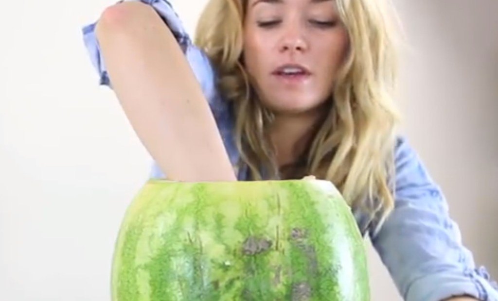 Eine Frau greift in die Wassermelone.