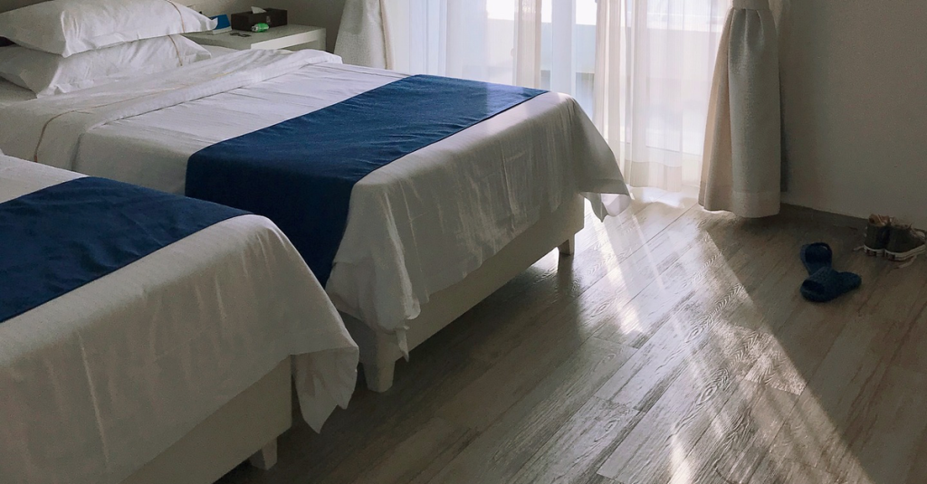 Zwei gemachte Betten in einem Hotelzimmer.