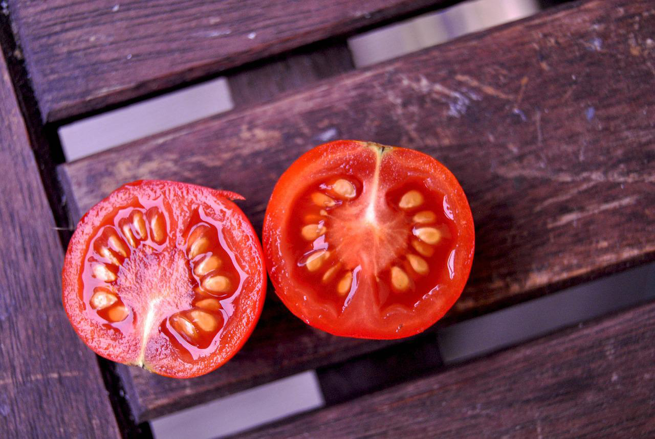 Eine mittig aufgeschnittene Tomate.