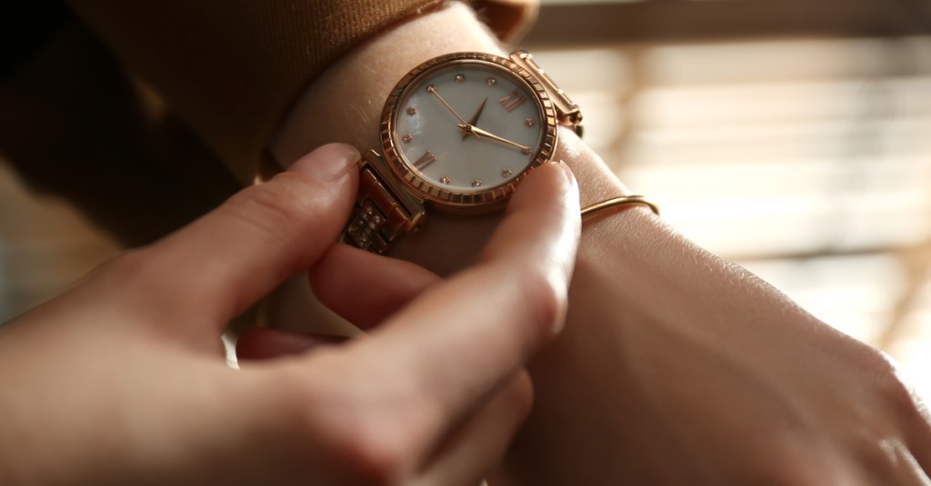 Eine Person schaut auf seine Armbanduhr.