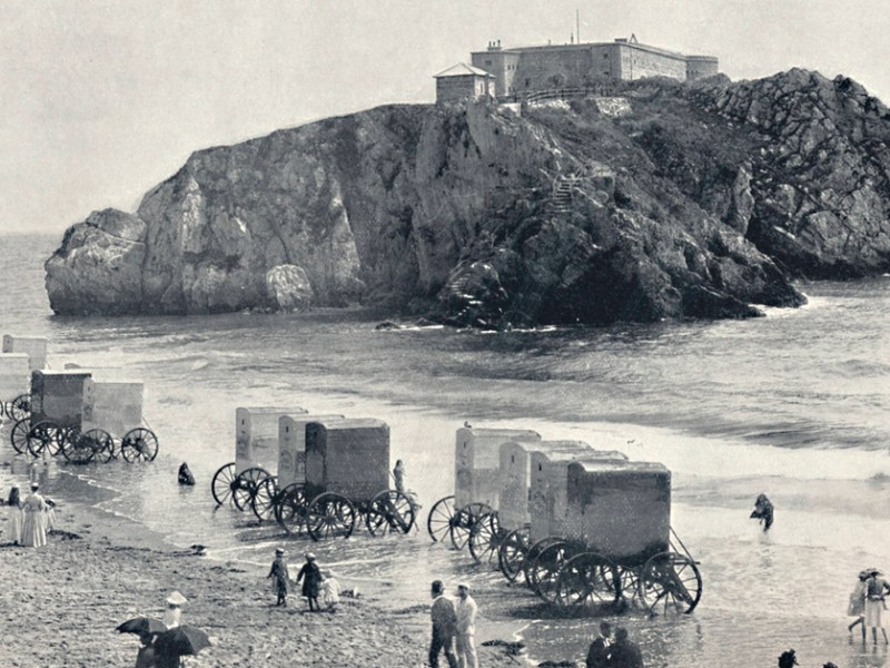 Historische Aufnahme zeigt Badekarren an einem Strand.