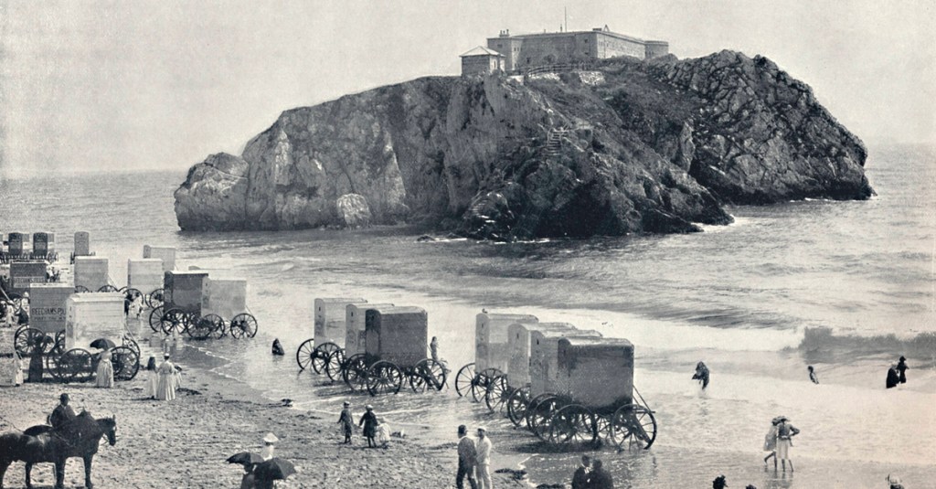 Historische Aufnahme zeigt Badekarren an einem Strand.