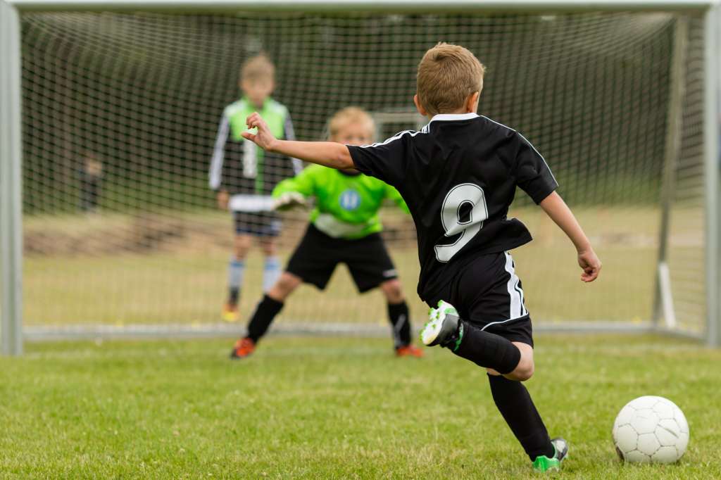 Kind spielt Fußball.