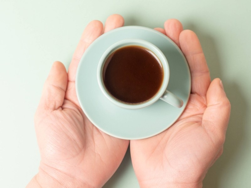 Kleine Tasse Kaffee in den HÃ¤nden halten.