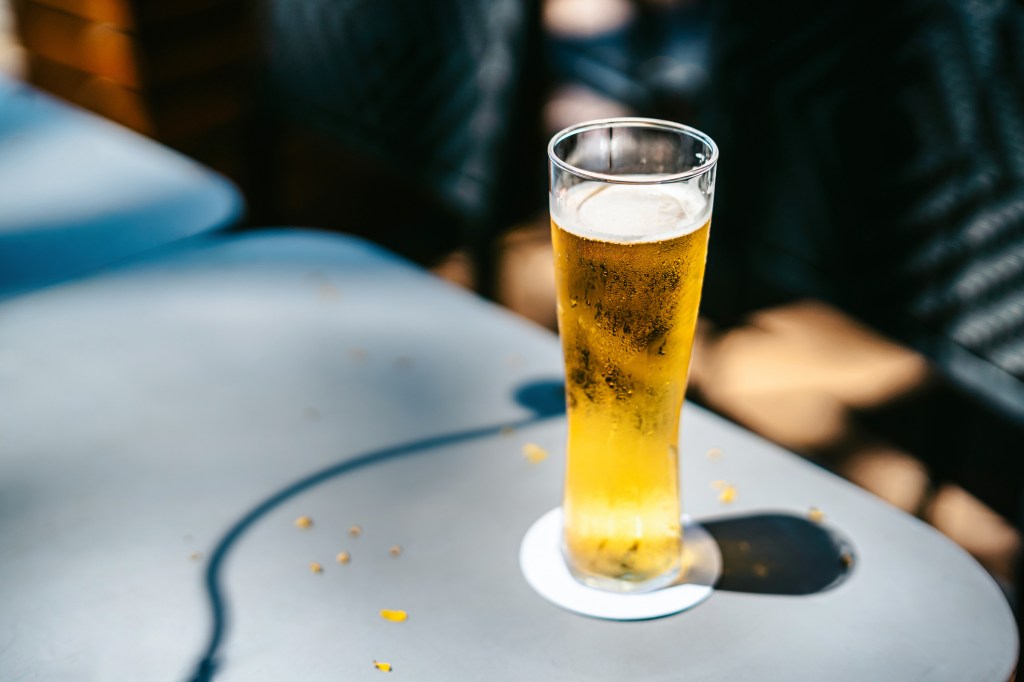 Ein Glas Bier steht in der Sonne.