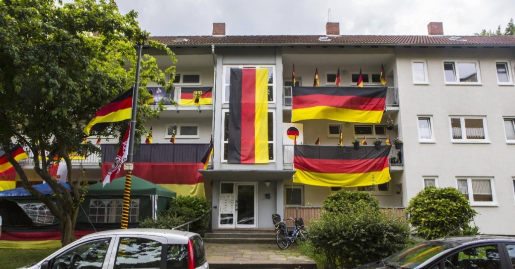 Ein Wohnhaus ist anlässlich einer Fußball-WM mit zahlreichen Flaggen geschmückt.