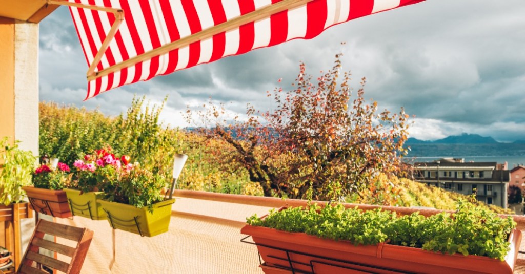 ein Balkon mit Balkonkästen und einer Markise