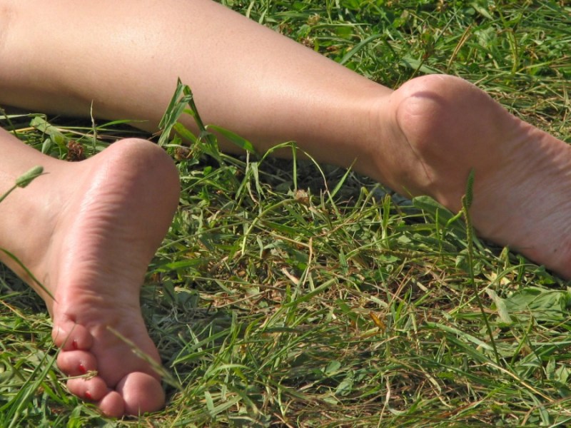 Frauenbeine auf Rasenfläche