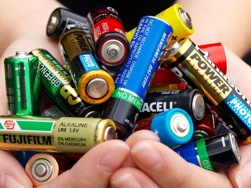 Zwei Hände halten viele Batterien