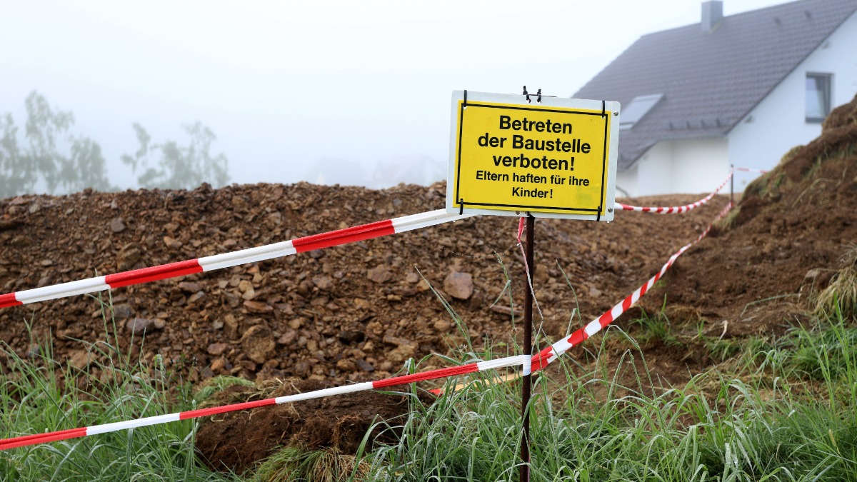 Schild mit der Aufschrift "Eltern haften für ihre Kinder" vor einer Baustelle