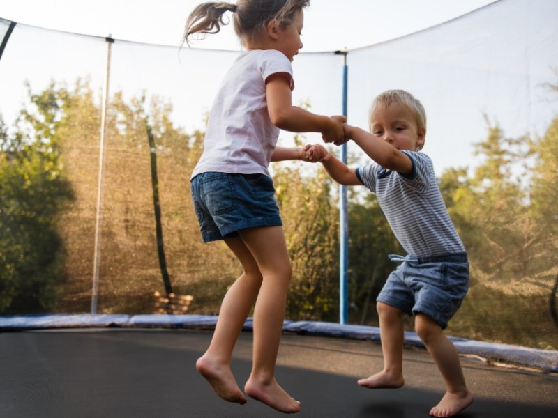 Zwei Kinder springen auf einem Trampolin