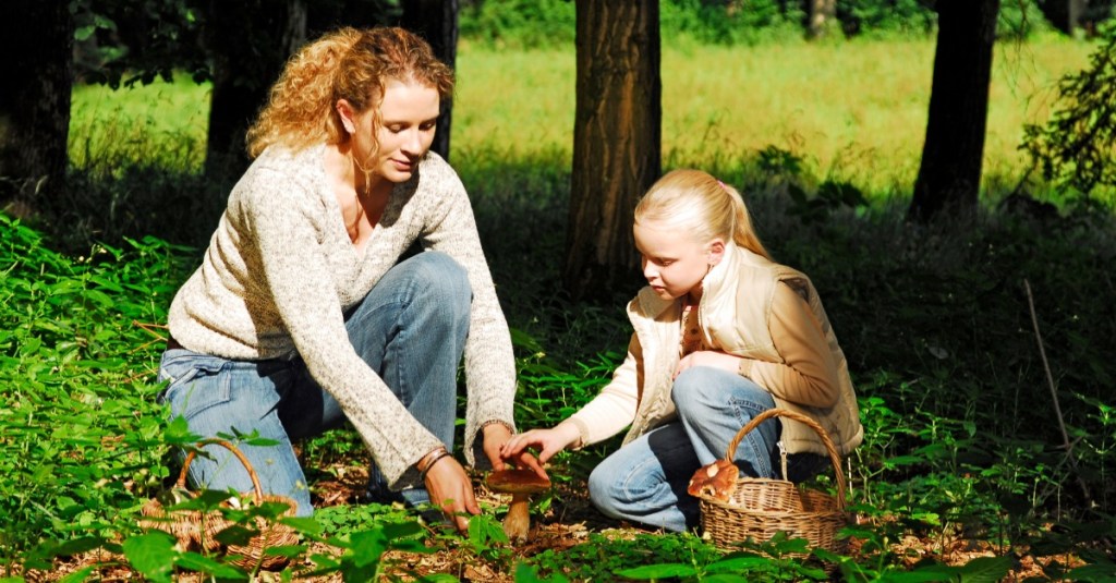 Mutter und Tochter sammeln Pilze im Wald