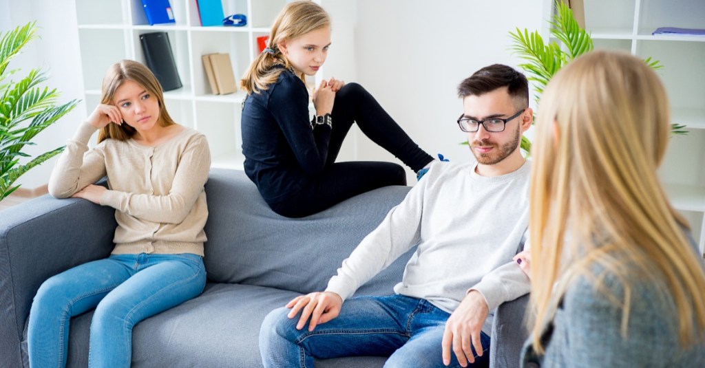 Familie sitzt auf dem Sofa und unterhält sich