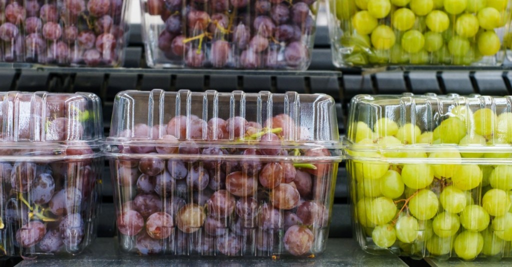 rote und grüne Weintrauben in Plastikverpackungen in einem Supermarktregal