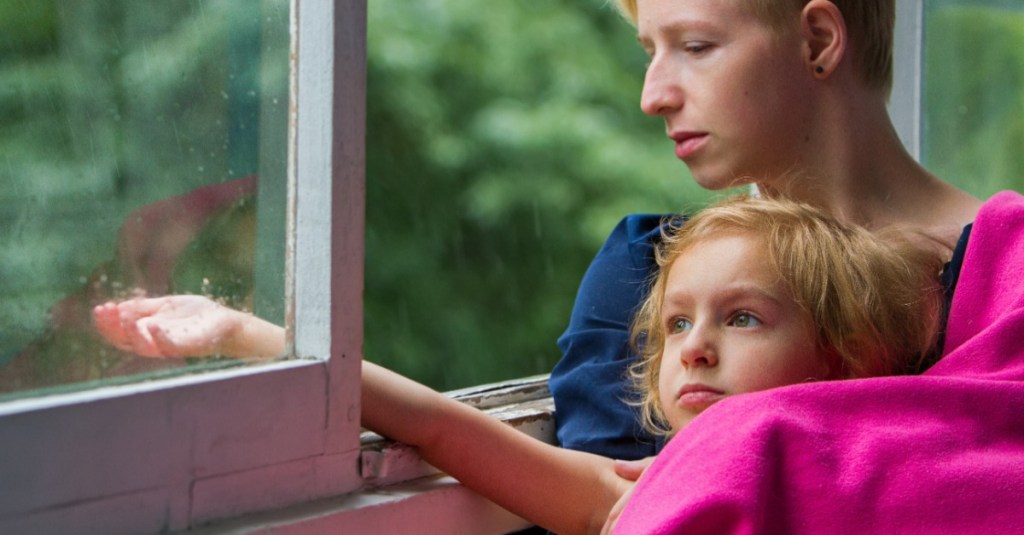 Mutter und Tochter sitzen am geöffneten Fenster