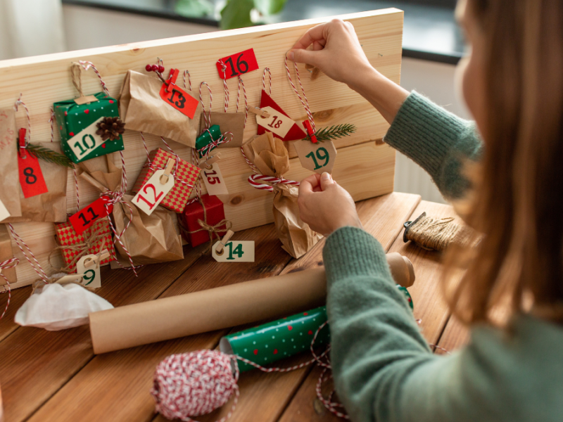 Frau öffnet Adventskalender für Frauen