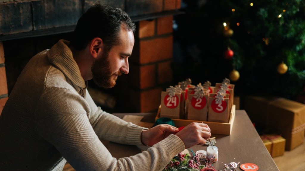 Ein Mann bastelt einen Adventskalender.