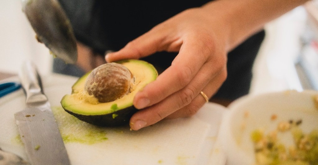 Avocado rote Flecken: eine Frau schneidet eine Avocado auf