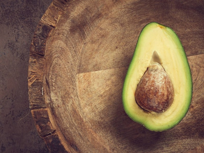 Avocado rote Flecken: eine Avocado liegt aufgeschnitten auf einem Küchenbrett