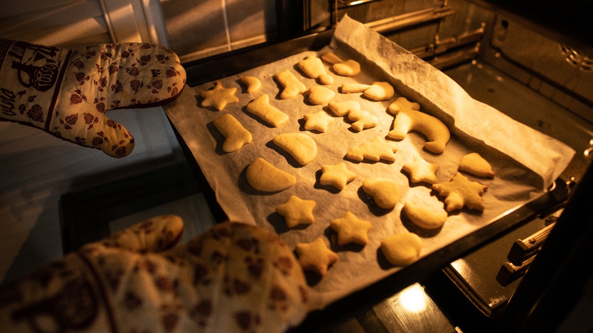 PlÃ¤tzchen backen: Ein Backblech mit PlÃ¤tzchen wird in den Ofen geschoben