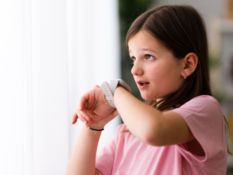 Smartwatch als Geschenk für Kinder: ein junges Mädchen spricht in eine Smartwatch