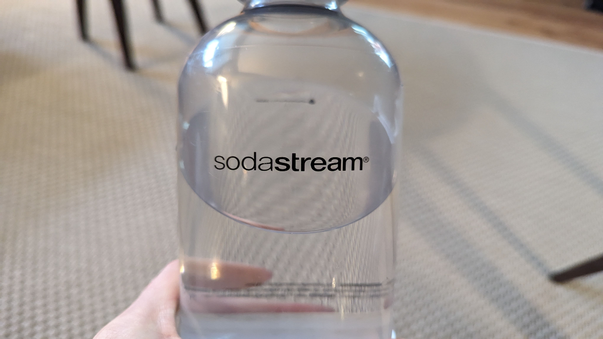 Eine Person hÃ¤lt eine Flasche von SodaStream.