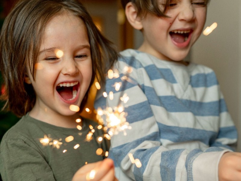 Silvester mit Kind: zwei kleine Jungs halten Wunderkerzen in den Händen