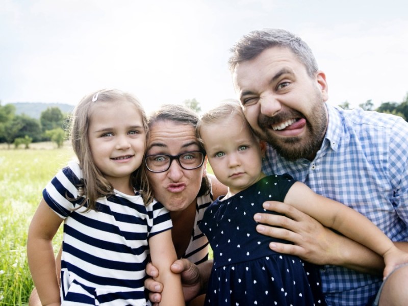 kreative Familienfotos: Vater, Mutter und zwei Kinder ziehen Grimassen für die Kamera