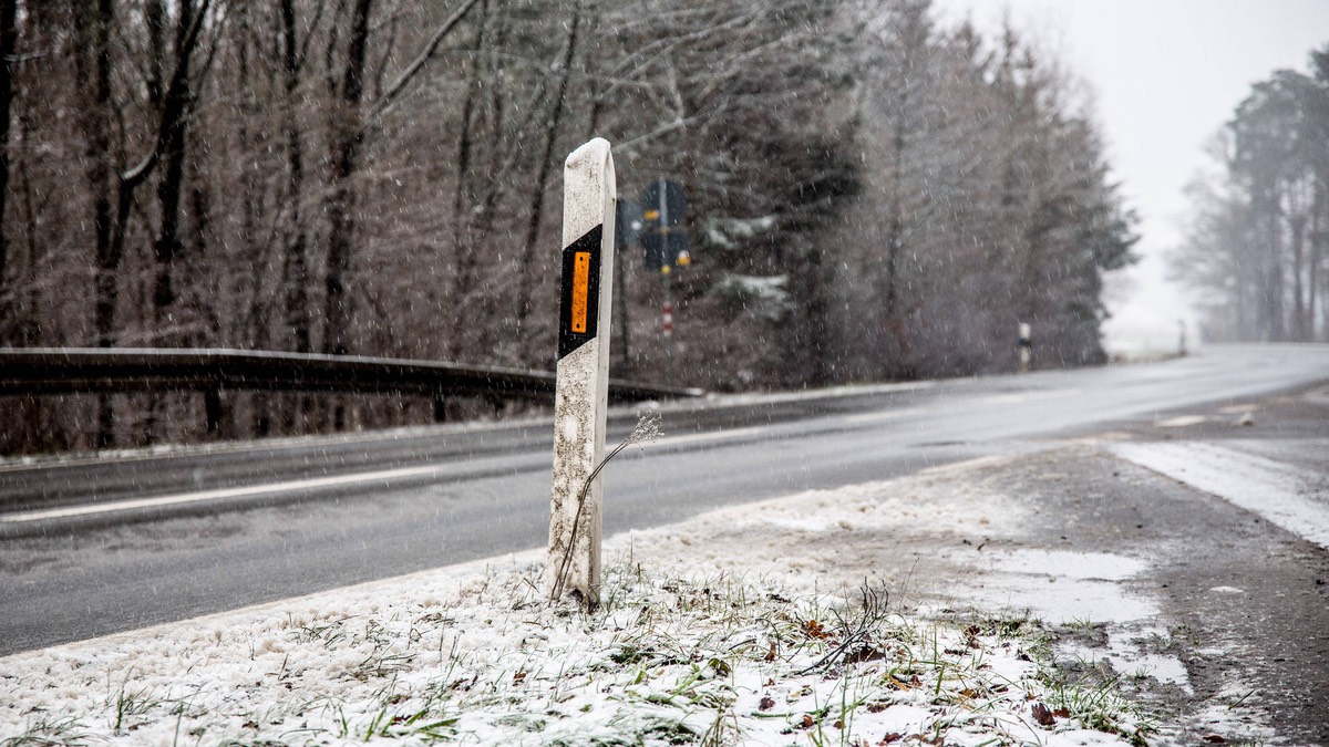 Leitpfosten am rechten StraÃŸenrand im Winter.