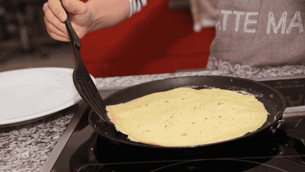 Schwarze Pfannenwender giftig, Crêpe in der Pfanne wird gewendet