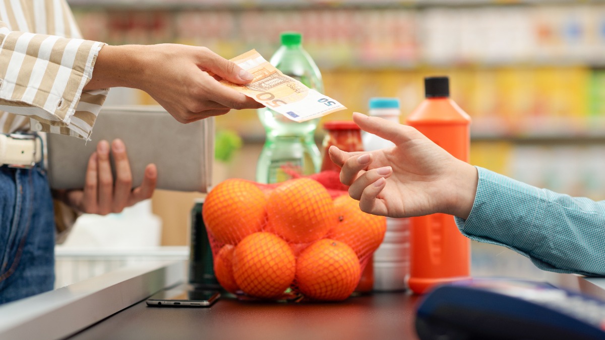 Eine Frau bezahlt mit einem 50-Euro-Schein an der Kasse im Supermarkt