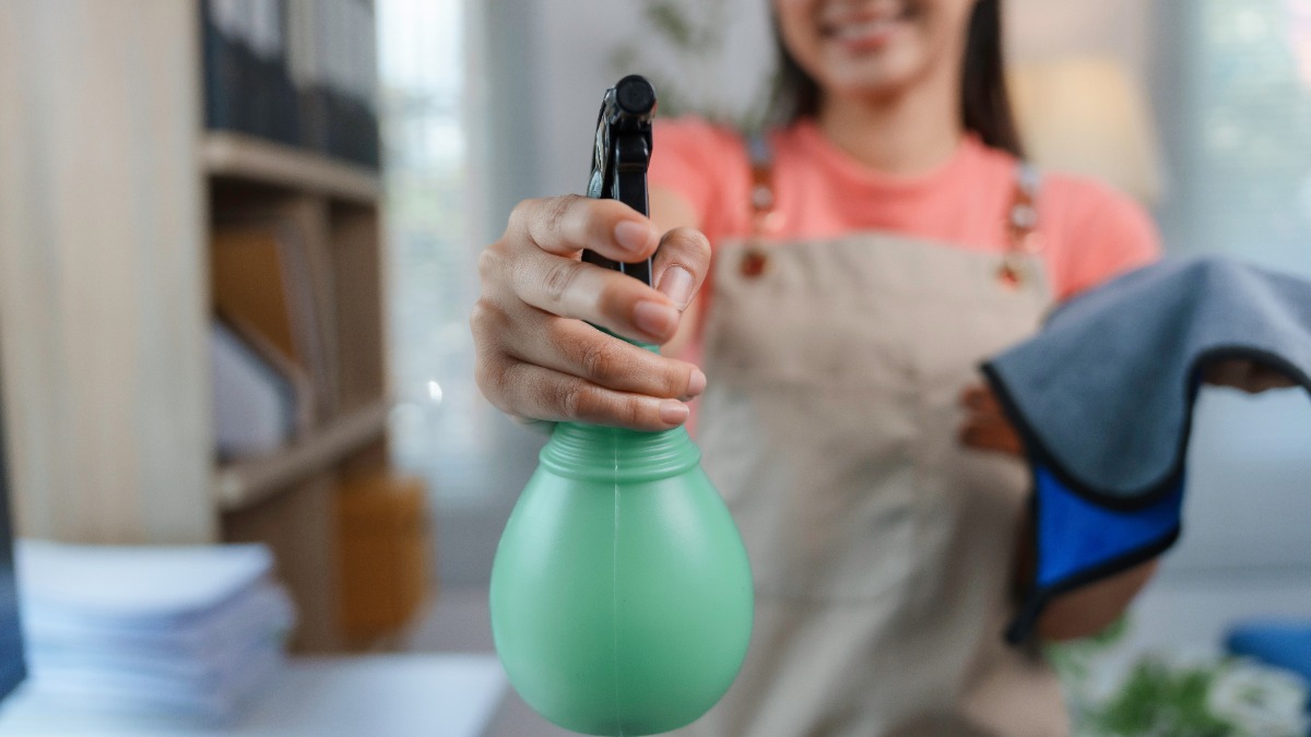 Cleanfluencer: eine Frau hält eine Sprühflasche in die Kamera