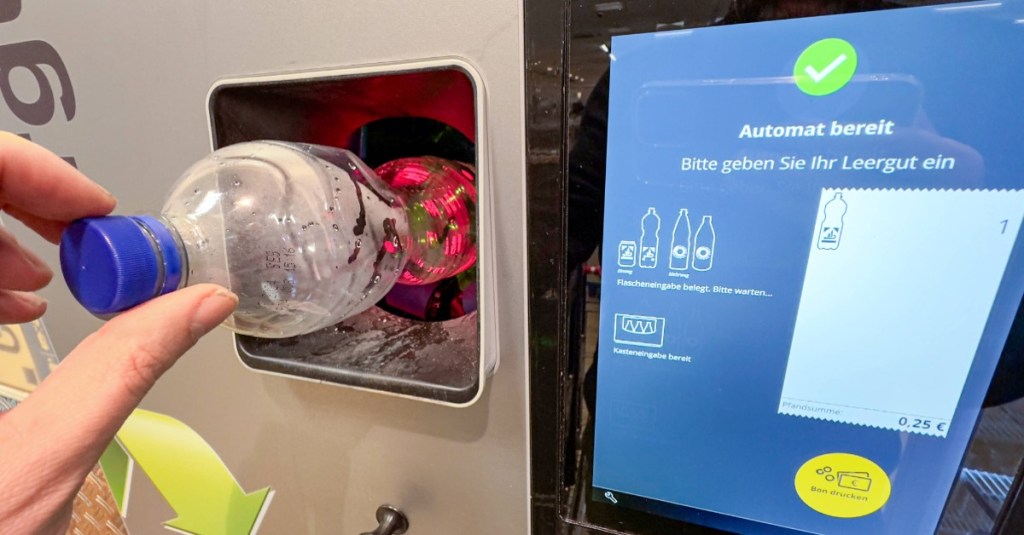 Mann beim Recycling von Plastikflaschen in einem Pfandautomaten, um Dosenpfand zu erhalten