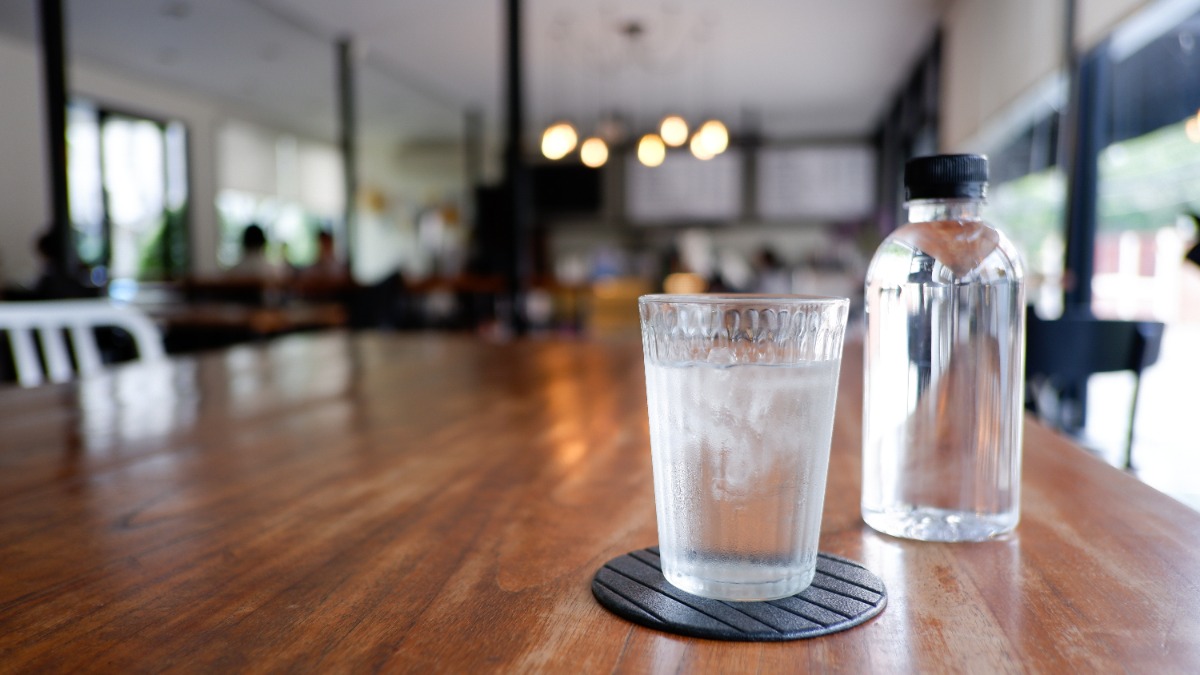 ein Glas und eine Karaffe mit Wasser stehen auf einem Tisch